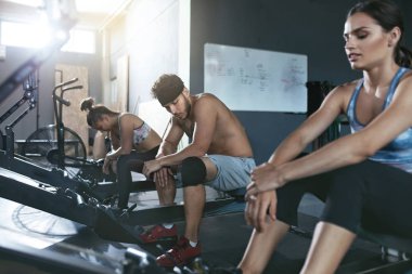 CrossFit. İnsanlar üzerinde kürek makine eğitim spor salonunda egzersiz