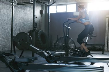 Spor salonunda egzersiz. Kadın eğitim Crossfit bisiklet üzerinde