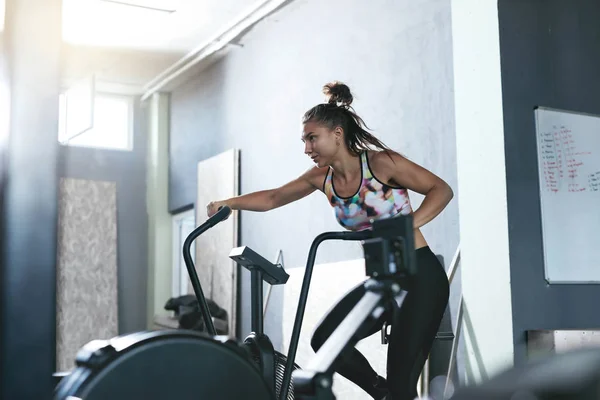 Entrenamiento Deportivo en Gimnasio. Entrenamiento de mujer en bicicleta Crossfit — Foto de Stock