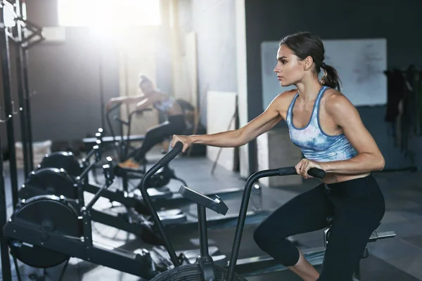 Sport edzhetnek az edzőteremben. A Crossfit kerékpár nő képzés — Stock Fotó
