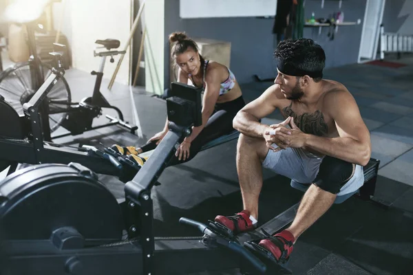 Gym. Man And Woman Training On Rowing Machine At Crossfit Club — Stock Photo, Image