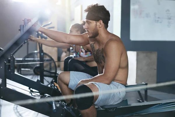 Gym. Man And Woman Training On Rowing Machine At Crossfit Club — Stock Photo, Image