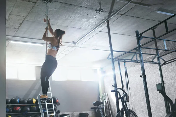 Entrenamiento en el gimnasio. Cuerda de escalada de atleta Crossfit femenina — Foto de Stock