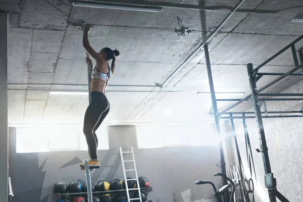 Entrenamiento en el gimnasio. Cuerda de escalada de atleta Crossfit femenina — Foto de Stock