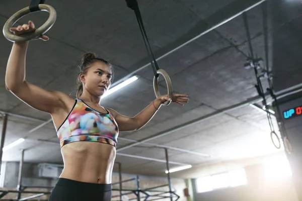 Crossfit. Sportlerin trainiert mit Gymnastikringen im Fitnessstudio — Stockfoto