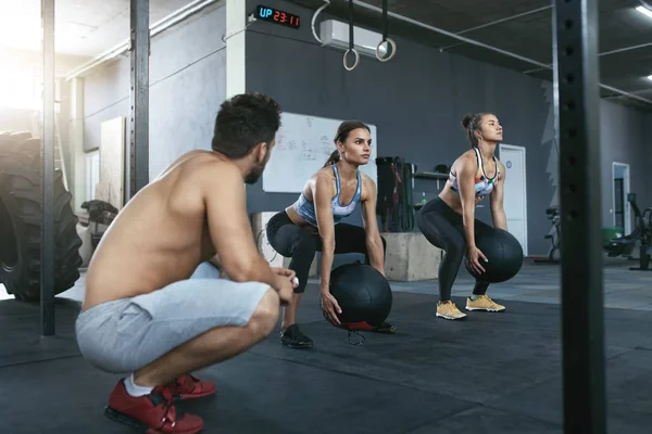 Sportfrauen trainieren mit Crossfit-Bällen im Fitnessstudio — Stockfoto
