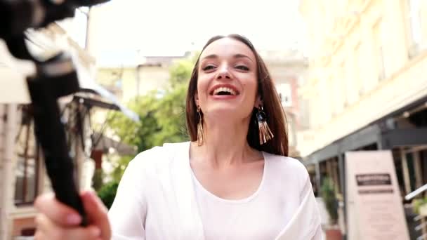 Вологинг. Женщина снимает видео на камеру на Сити-стрит — стоковое видео