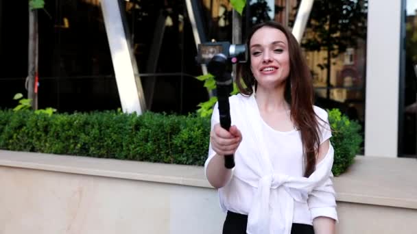 Video Blogging. Mujer con cámara cerca de moderno edificio de negocios — Vídeos de Stock