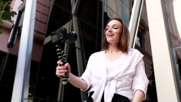 Video Blogging. Mujer con cámara cerca de moderno edificio de negocios — Vídeo de stock