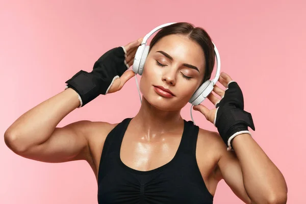 Sport nő hallgat zenét fejhallgató a képzés — Stock Fotó