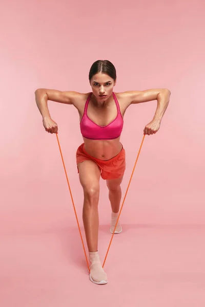 Allenati. Formazione donna con bande di resistenza su sfondo rosa — Foto Stock