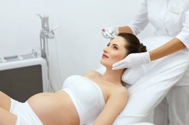 Face Skin Cryo Therapy. Pregnant Woman At Cosmetology Treatment clipart