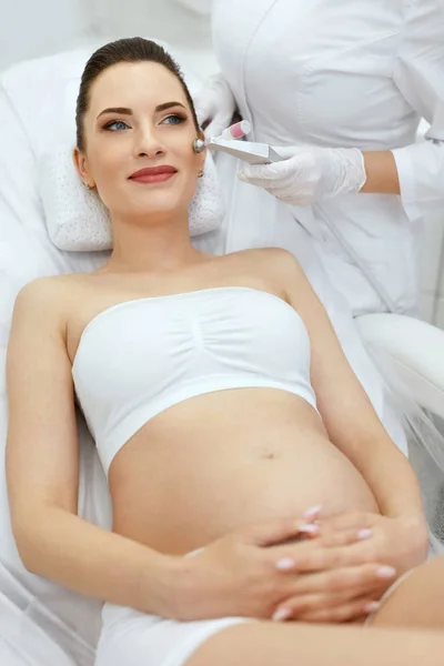 Tratamiento de belleza. Mujer embarazada recibiendo terapia en la piel facial — Foto de Stock