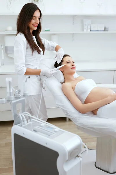 Clínica de Cosmetologia. Mulher grávida obtendo rosto pele descascando — Fotografia de Stock