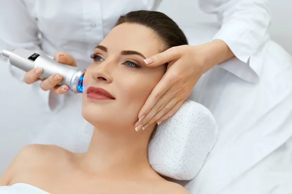 Hudvård för ansiktet. Kvinnan gör blått ljus terapi på skönhetsklinik — Stockfoto