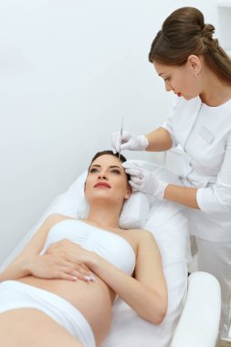 Temizlik yordamı yüz. Hamile kadın kozmetik kliniğinde