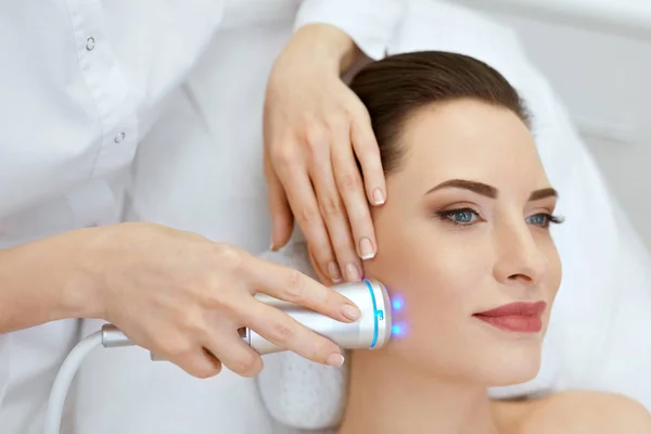 Красота. Женщина делает синее легкое лечение лица на коже лица — стоковое фото