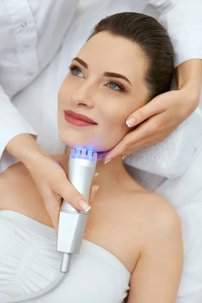 Cosmetología de la piel facial. Primeros planos mujer haciendo azul tratamiento de la luz — Foto de Stock