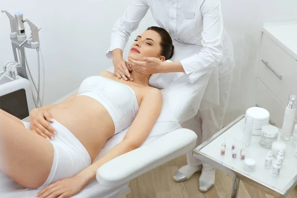 Gesichtshaut massieren. Schwangere in Kosmetologie-Klinik — Stockfoto