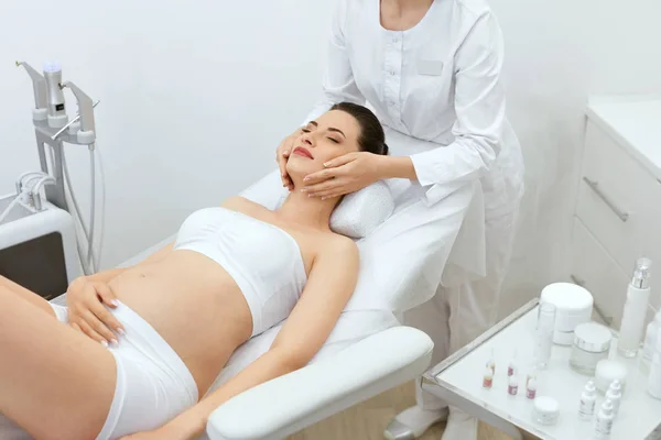 Gezicht huid Massage. Zwangere vrouw bij cosmetologie kliniek — Stockfoto