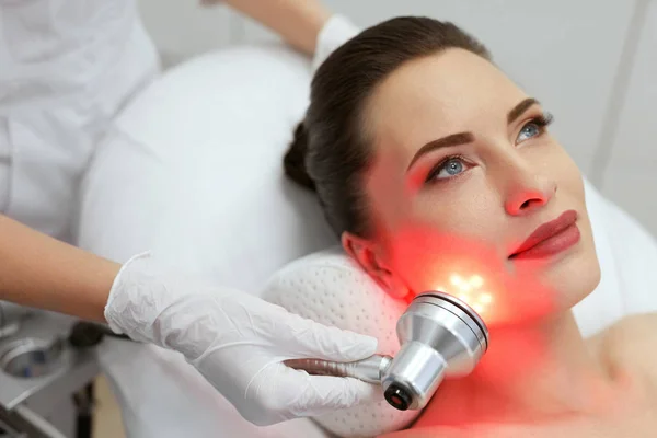 Gezichtsschoonheidsbehandeling. Vrouw doet Red Led Light Therapy — Stockfoto