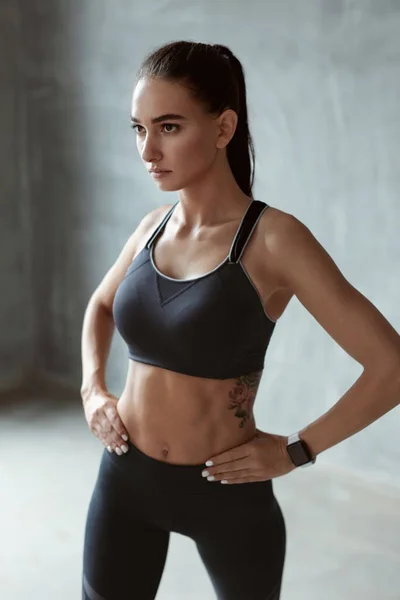 Mujer de los deportes en ropa deportiva de moda sobre fondo gris —  Fotos de Stock