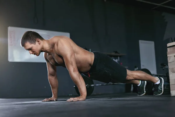 Entrenamiento. Hombre deportivo haciendo push ups desde el piso en el club deportivo —  Fotos de Stock