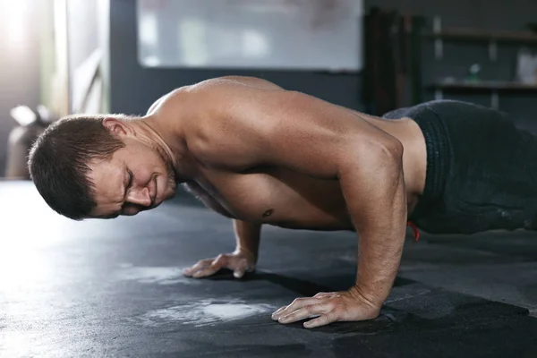 Entrenamiento. Hombre deportivo haciendo push ups desde el piso en el club deportivo —  Fotos de Stock
