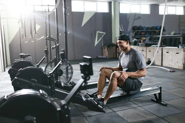 Gimnasio. Deportes Hombre de entrenamiento en la máquina de remo — Foto de Stock