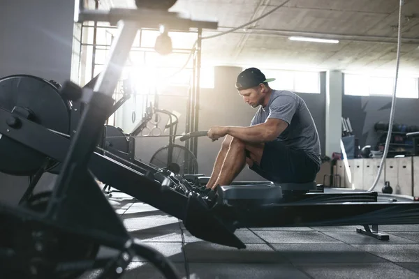 Funktionstraining. Mann turnt im Fitnessstudio auf Rudergerät — Stockfoto