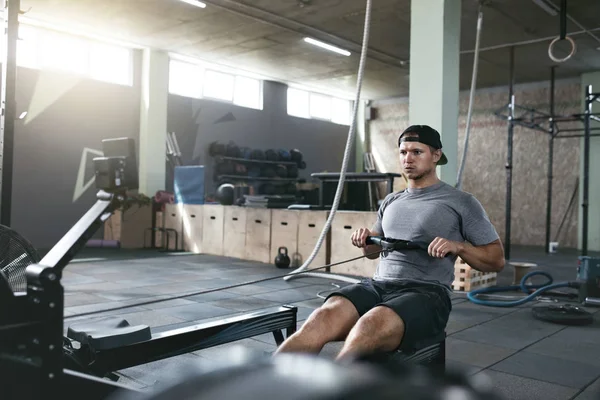 Kardiyo egzersizi. Kürek makine spor salonunda egzersiz spor adamı — Stok fotoğraf