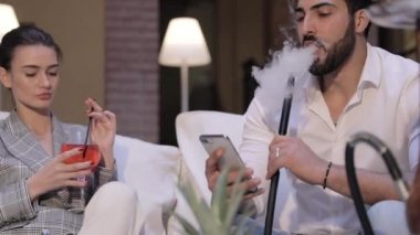 Çift Shisha barda. Nargile sigara ve istimal telefon adam