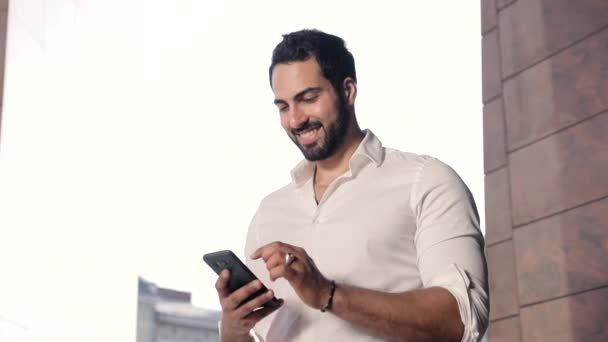 Hombre usando el teléfono móvil al aire libre en el día soleado — Vídeos de Stock