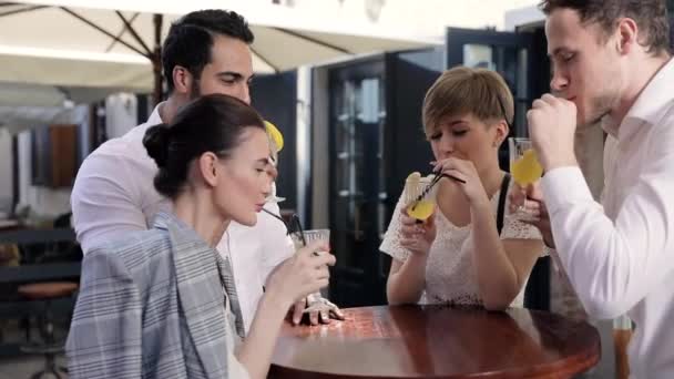 Jóvenes bebiendo cócteles en City Street Café — Vídeo de stock