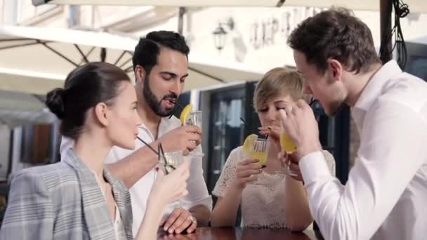 Jugendliche trinken Cocktails im Straßencafé der Stadt — Stockvideo