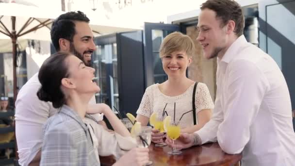 Молодые люди пьют коктейли в кафе City Street — стоковое видео