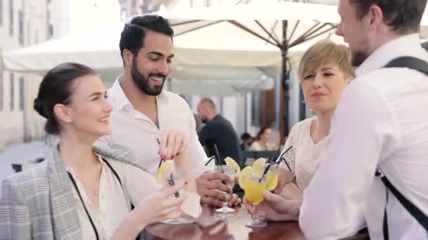 Jóvenes bebiendo cócteles en City Street Café — Vídeo de stock