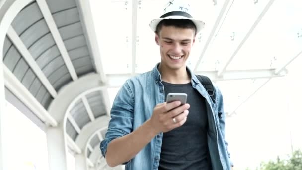 Ταξιδεύουν. Χαμογελαστός άνθρωπος με αποσκευές χρησιμοποιώντας το κινητό τηλέφωνο — Αρχείο Βίντεο