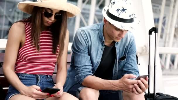 Coppia con telefoni in attesa in aeroporto — Video Stock