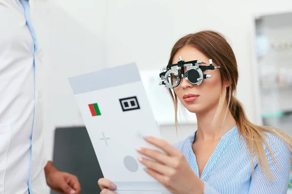 Eye Exam. Woman In Optometry Glasses Reading Eye Test Card — Stock Photo, Image