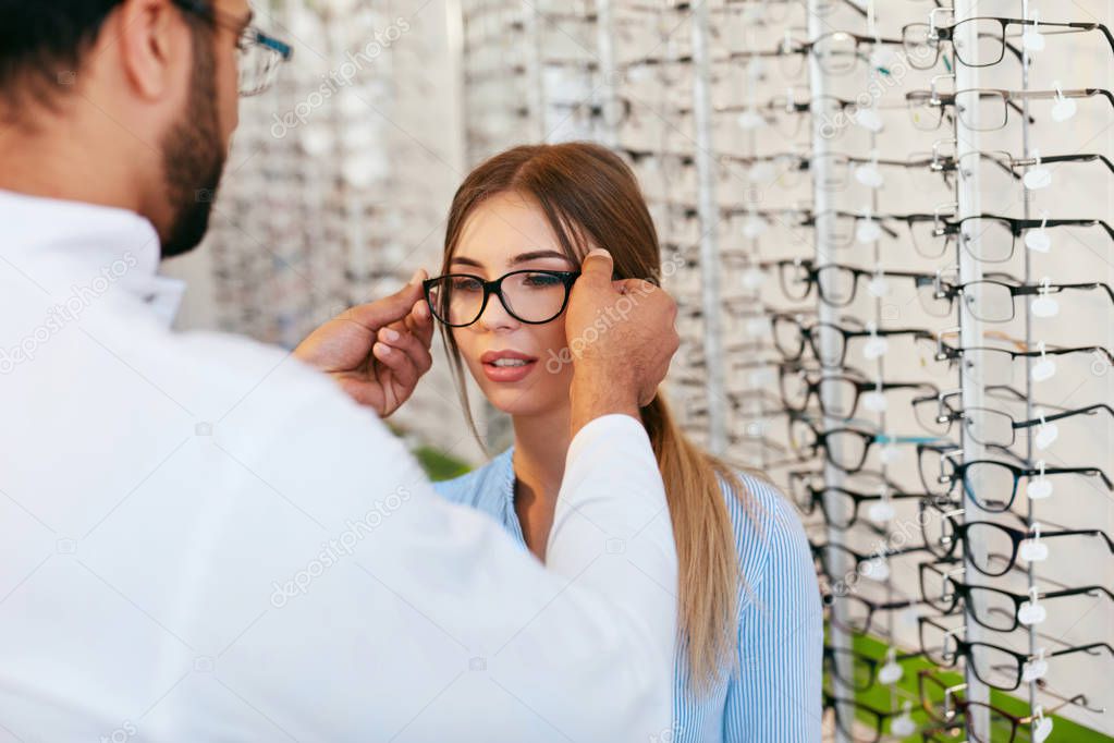 Optical Store. Eye Doctor Helping Woman Choosing Eyeglasses