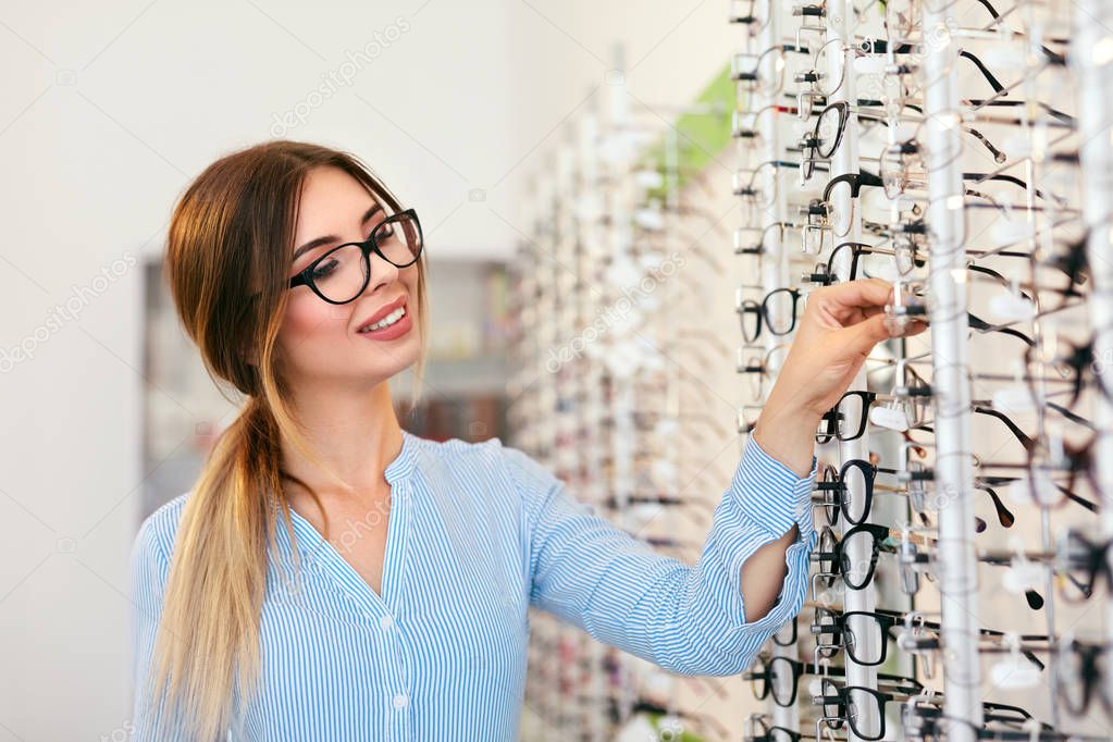 Eyeglasses Store. Woman Choosing Glasses For Eyesight Correction