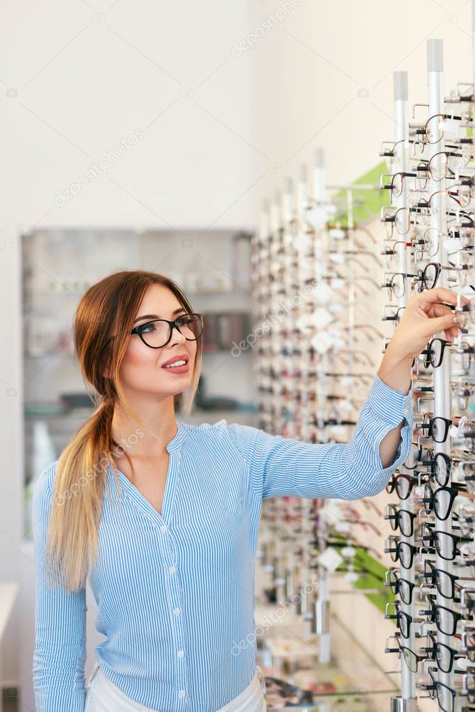Eyeglasses Store. Woman Choosing Glasses For Eyesight Correction