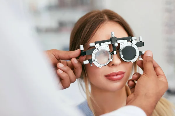 Экзамен на зрение. Женщина в очках проверяет зрение в клинике — стоковое фото