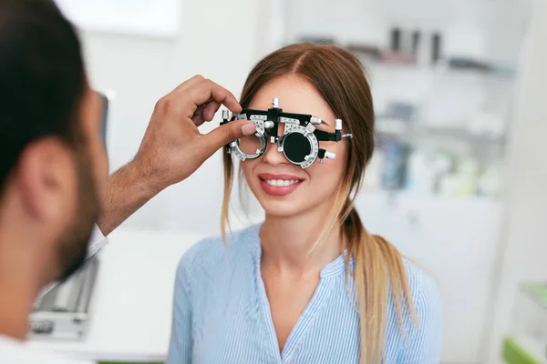 Оптометрический тест. Глазной врач проверяет зрение женщины в клинике — стоковое фото