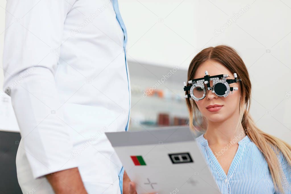 Eye Exam. Woman In Optometry Glasses Reading Eye Test Card
