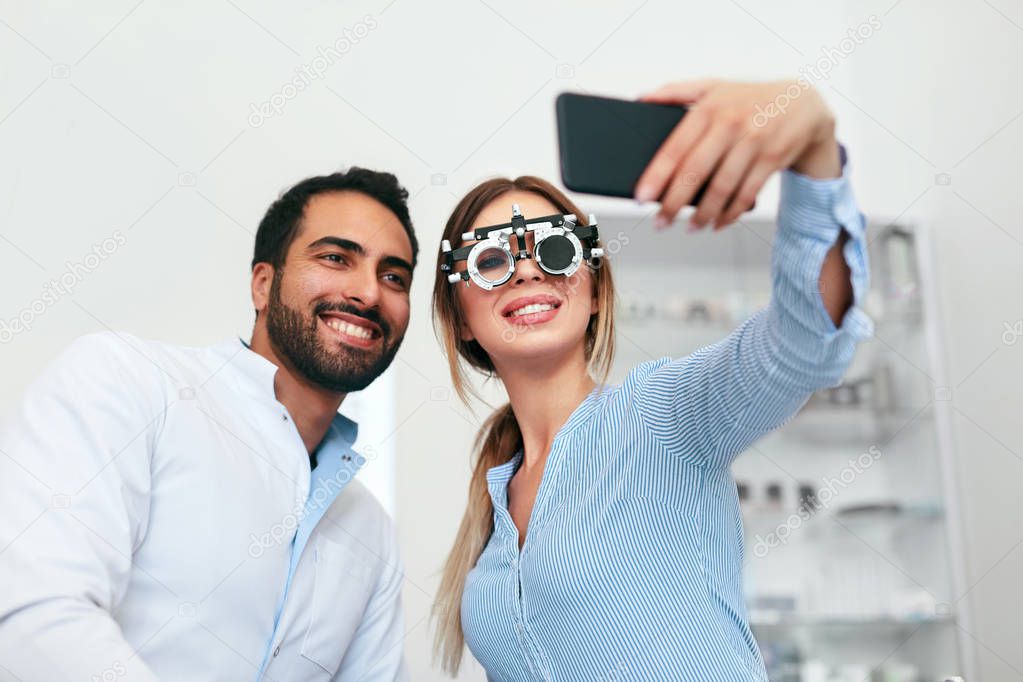 Eye Center. Woman Making Photo On Phone With Doctor On Eye Exam