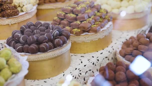 Schokoladenladen. Schokoladenbonbons in den Regalen im Geschäft — Stockvideo