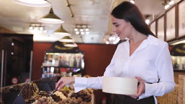 Loja de Chocolate. Vendedor feminino na loja de confeitaria — Vídeo de Stock