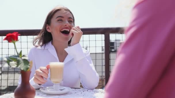 Woman Drinking Coffee At Cafe With Friend Outdoors — Stock Video